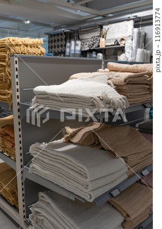 The textile products are folded on shelves in the store. The textile products are folded on shelves in the store. 116913774