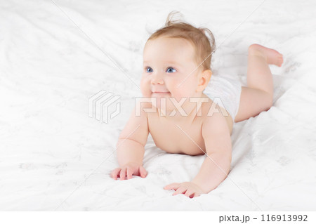 Little baby on white bed 116913992