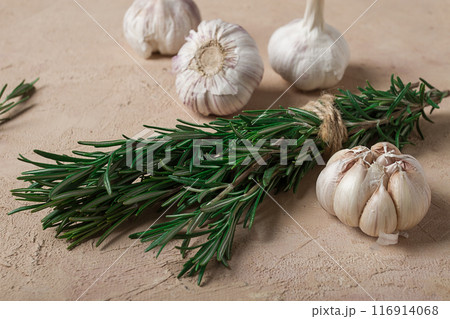 fresh bunch of rosemary with garlic, on a beige background, food concept, 116914068