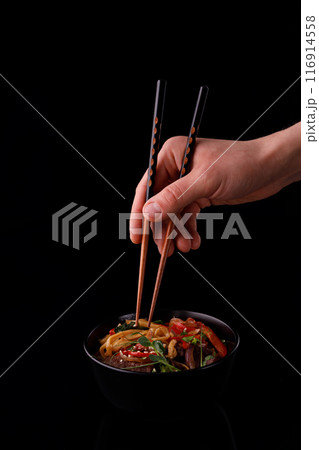 Stir fry noodles with vegetables and shrimps in black bowl. Slate background. Top view. Copy space. Stir fry noodles with vegetables and shrimps in black bowl. Slate background. Top view. Copy space. 116914558