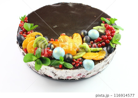 KYIV, UKRAINE Chocolate cake decorated with blueberries, cookies and bubble chocolates on a black background. Brown cream cheese frosting with dark chocolate drips on birthday cake KYIV, UKRAINE Chocolate cake decorated with blueberries, cookies and bubble chocolates on a black background. Brown cream cheese frosting with dark chocolate drips on birthday cake 116914577