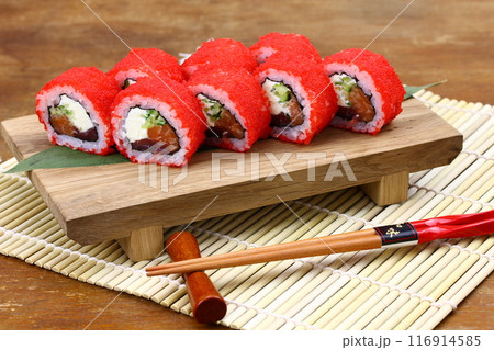 Sushi delivery. Set of rolls in a disposable box on a black background. Top view 116914585