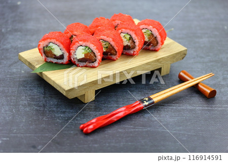 Sushi delivery. Set of rolls in a disposable box on a black background. Top view 116914591