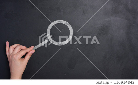 A woman's hand and a magnifying glass drawn with white chalk on a black chalk board 116914842