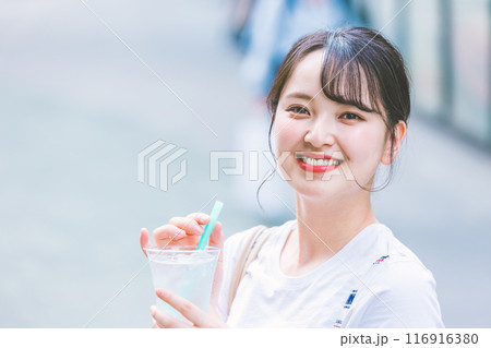 屋外で水を飲む若い女性 116916380