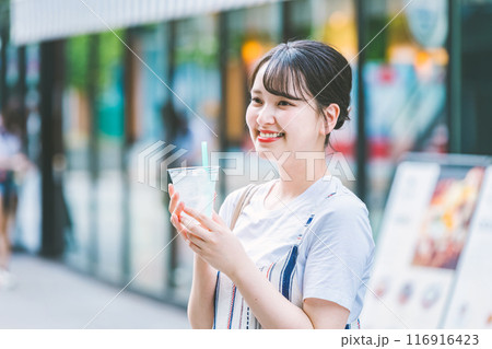 屋外で水を飲む若い女性 116916423