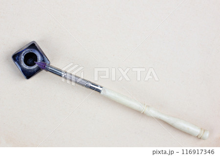 Vintage pen and inkwell on paper background 116917346