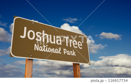 Joshua Tree National Park (California) Road Sign Against Blue Sky and Clouds. Joshua Tree National Park (California) Road Sign Against Blue Sky and Clouds. 116917734
