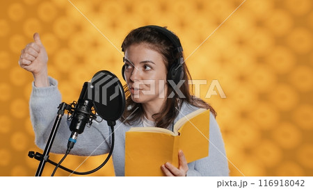 Voice actor looking to producer off camera to know when to start narrating book, producing audiobook. Narrator doing counting on fingers gesturing before starting digital recording of novel, camera A Voice actor looking to producer off camera to know when to start narrating book, producing audiobook. Narrator doing counting on fingers gesturing before starting digital recording of novel, camera A 116918042