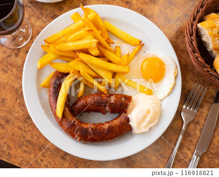 Fried sausages with French fries and egg 116918821