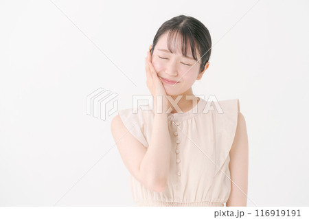 頬をさわる笑顔の20代女性 116919191
