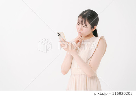 スマホを見て考える若い女性 116920203