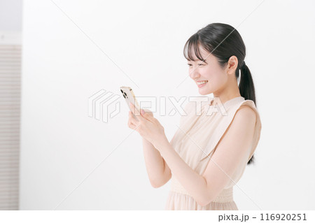 スマホを見る笑顔の若い女性 116920251