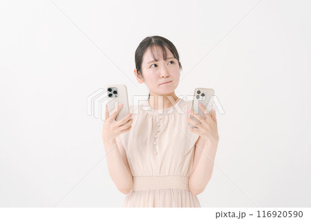 2台のスマホを持つ若い女性 116920590