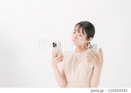 2台のスマホを持つ若い女性 2台のスマホを持つ若い女性 116920591