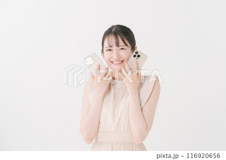 2台のスマホを持つ若い女性 2台のスマホを持つ若い女性 116920656