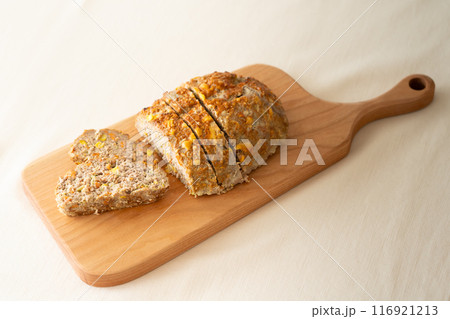 木のカッティングボードと野菜入りミートローフ 116921213