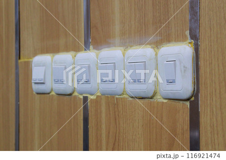 row of wooden wall light switches 116921474