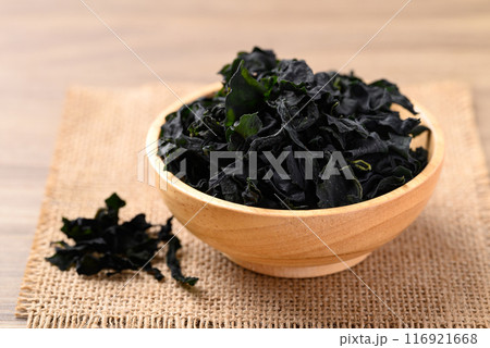 Dried Wakame seaweed or sea mustard in wooden bowl 116921668