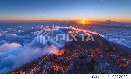 A sunrise viewed from a mountain peak, with clouds below and a glowing horizon, offers a serene experience. A sunrise viewed from a mountain peak, with clouds below and a glowing horizon, offers a serene experience. 116922035