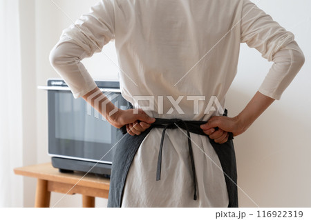 エプロンを結んでキッチンに立つ女性の後ろ姿 エプロンを結んでキッチンに立つ女性の後ろ姿 116922319