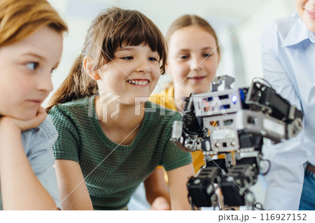 Children learning robotics in Elementary school. Young students building robot in after school robotics club. Field trip to real robotics laboratory. 116927152