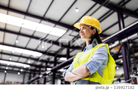 Manager woman in business casual clothes and reflective safety clothes controlling goods in warehouse. Manager woman in business casual clothes and reflective safety clothes controlling goods in warehouse. 116927182
