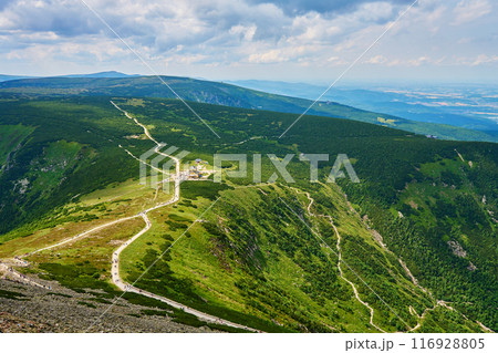 Beautiful panoramic view of green mountain valley with winding mountain trail leading to summit of Sniezka and hiker tourists on path in Karpacz, Poland. Travel tourism and hiking concept 116928805