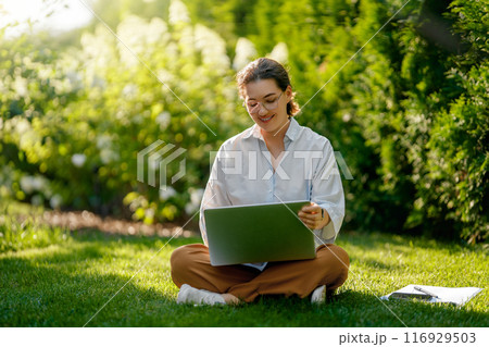 woman working on laptop in summer morning woman working on laptop in summer morning 116929503