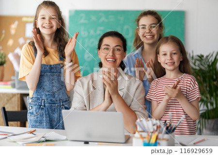 Happy kids and teacher at school Happy kids and teacher at school 116929659