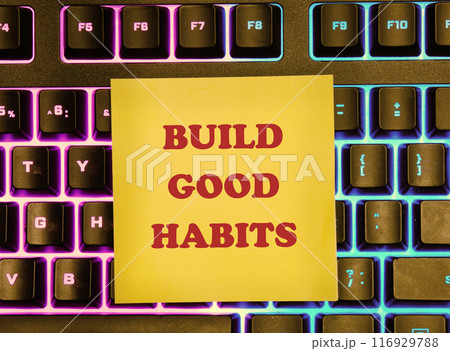 Business, psychological build good habits concept. Concept words Build good habits on a yellow sticker on the background of a backlit keyboard 116929788