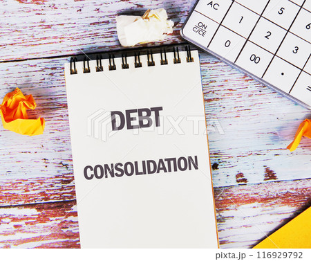 Business concept. DEBT CONSOLIDATION words in a white notebook on old boards Business concept. DEBT CONSOLIDATION words in a white notebook on old boards 116929792