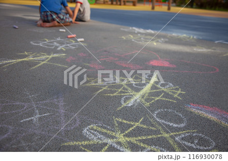 The game tic-tac-toe is drawn on the asphalt. Children play outside. Drawing with colored chalk. The game tic-tac-toe is drawn on the asphalt. Children play outside. Drawing with colored chalk. 116930078