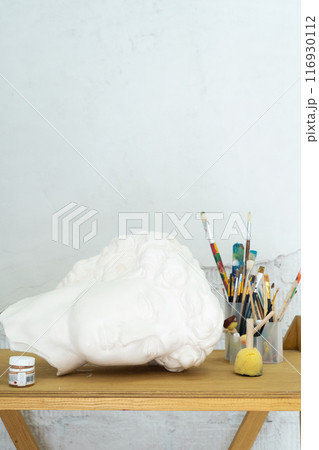 An Artistic Workspace that showcases a Bust along with a range of Painting Supplies for creative expression 116930112