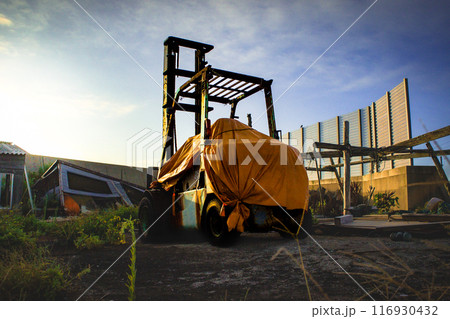 港町で使われなくなり放置されたフォークリフト 116930432