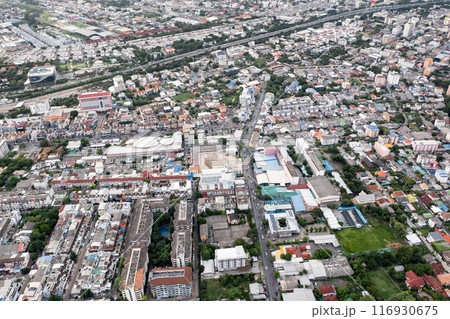 Aerial view of a large city There are many houses arranged in proportions which have a road cut through and a little green area. Aerial view of a large city There are many houses arranged in proportions which have a road cut through and a little green area. 116930675
