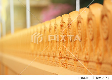 Buddhist temple wall in Orange Yellow color have pattern with beautifully carved and refined. Buddhist temple wall in Orange Yellow color have pattern with beautifully carved and refined. 116930964