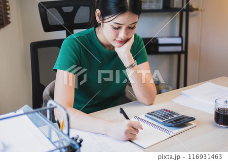 Woman working by using calculator. 116931463