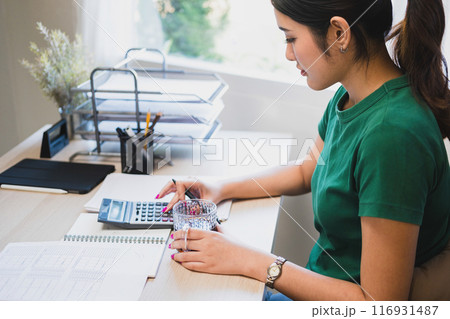 Woman working by using calculator. Woman working by using calculator. 116931487