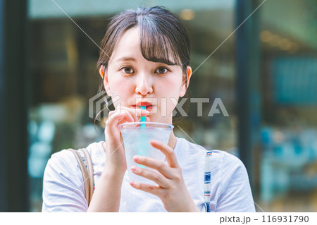 屋外で水を飲む若い女性 116931790