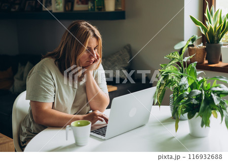 Stressed business woman working from home on laptop looking worried, tired and overwhelmed. Home work Stressed business woman working from home on laptop looking worried, tired and overwhelmed. Home work 116932688
