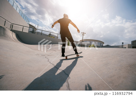 Skateboarder skateboarding at skatepark in city Skateboarder skateboarding at skatepark in city 116932794