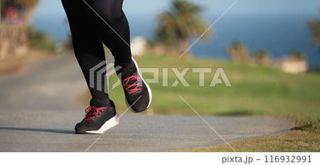 Young fitness woman legs, running in the city public park in morning Young fitness woman legs, running in the city public park in morning 116932991