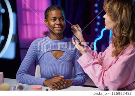 Portrait of two girls doing make up tutorial and recording video with ring light for social media 116933452