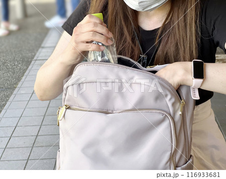 バッグにペットボトルを入れる女性 116933681