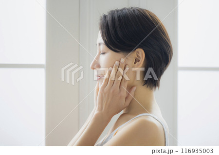 リビングで鏡を見るミドルの女性　 116935003