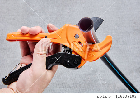 Ratchet type PVC pipe cutter, one hand fast pipes cutting tool on gray background. Ratchet type PVC pipe cutter, one hand fast pipes cutting tool on gray background. 116935105