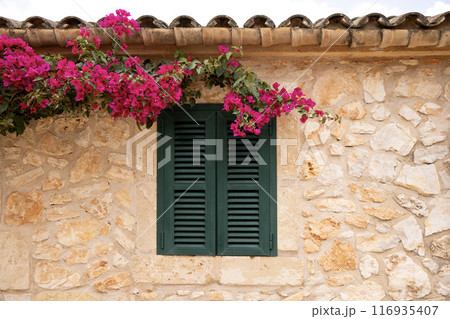 old green window in Mallorca, typical stone house, Spain 116935407