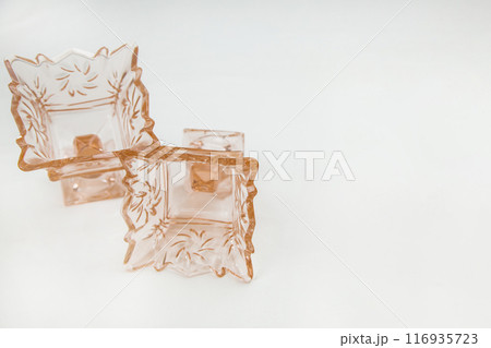 Two empty crystal cremans or vases on a stem for ice cream or salads of peach or orange color lie in close-up on a white background with a place for text. High quality photo 116935723