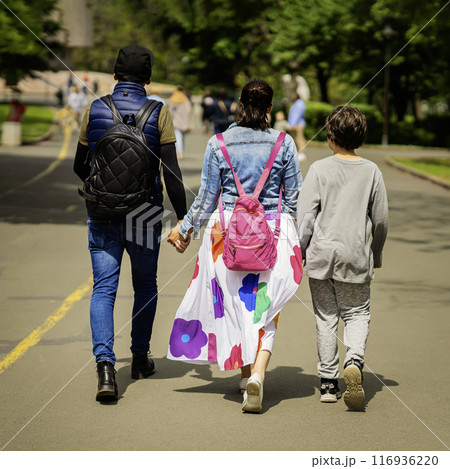 Friendly family, parents and son walk in park, holding hands. Concept of love, joint recreation 116936220